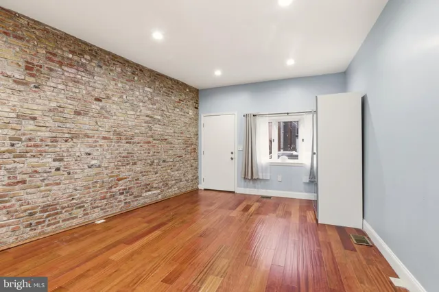 a view of a hallway with wooden floor and entryway