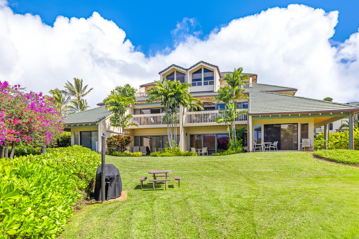 2371 Ho'ohu Road, Unit 703 Koloa, HI 96756 - Photo 2 of 27 a front view of a building with a garden and trees