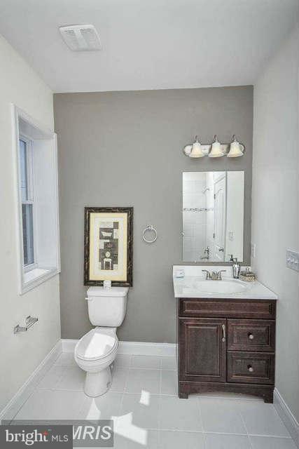 3616 Reisterstown Road Baltimore, MD 21215 - Photo 23 of 26 a bathroom with a toilet a sink and mirror
