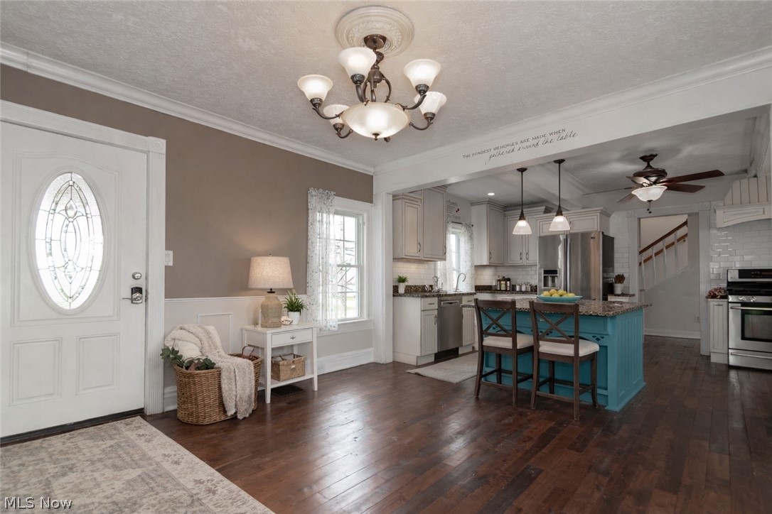 30200 Ridge Road Wickliffe, OH 44092 - Photo 7 of 43 Foyer entrance featuring dark wood-style floors, ceiling fan, crown molding, suspended lighting, and a textured ceiling