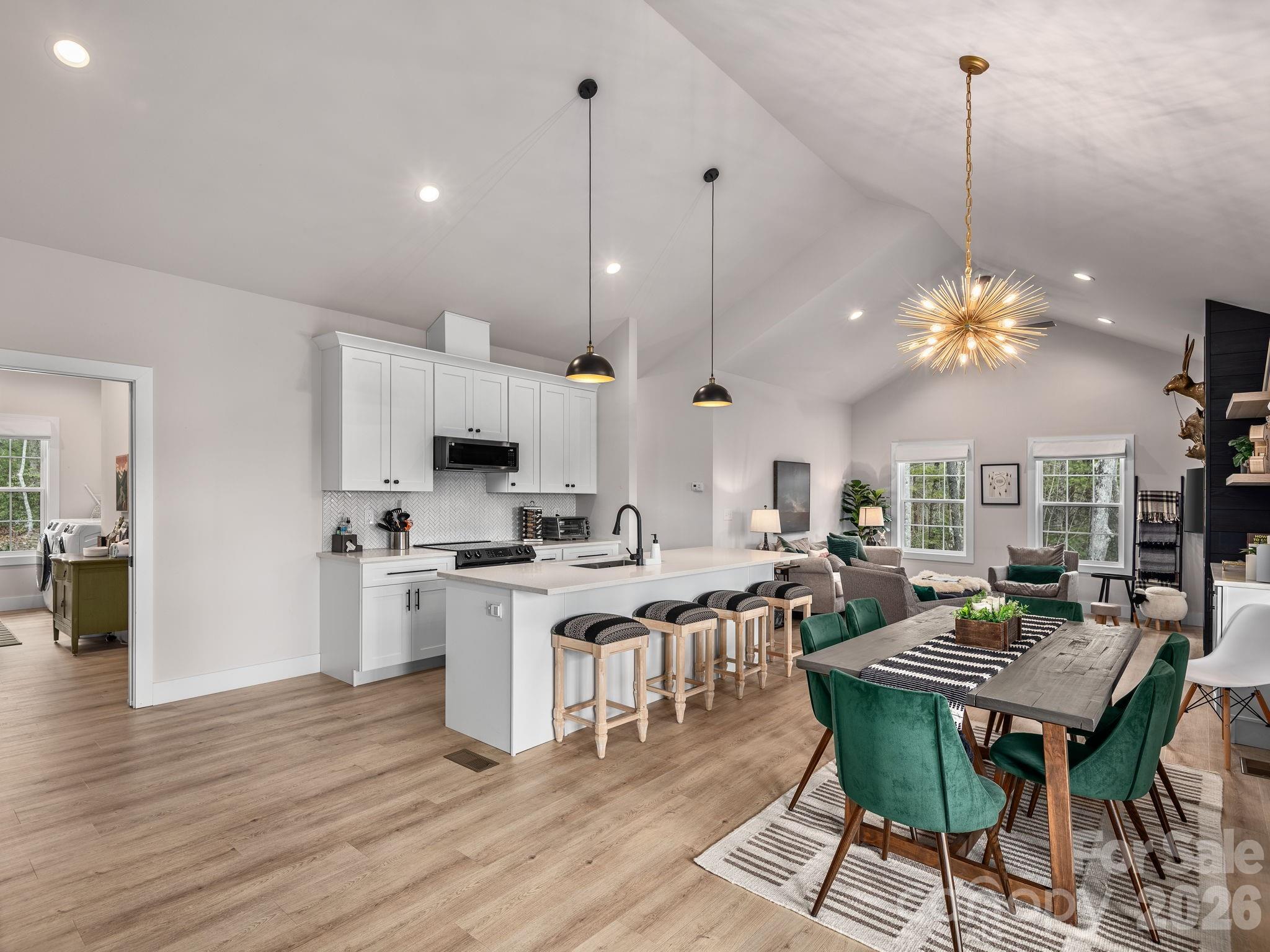 2201 Bulling Creek Road Hendersonville, NC 28739 - Photo 11 of 47 a open kitchen with stainless steel appliances granite countertop a stove top oven a dining table and chairs with wooden floor