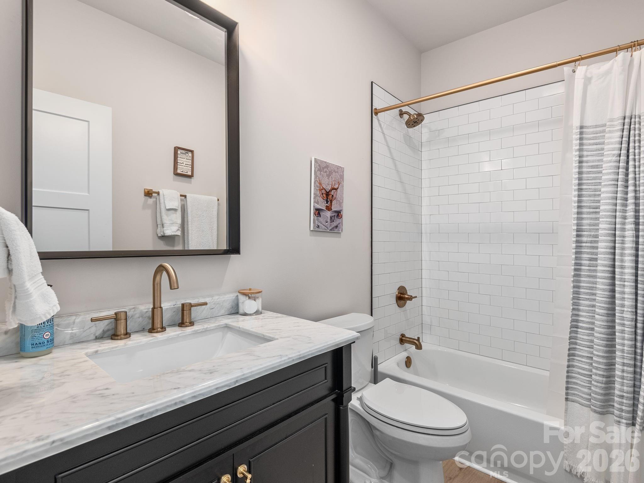 2201 Bulling Creek Road Hendersonville, NC 28739 - Photo 25 of 47 a bathroom with a granite countertop sink toilet a shower and a mirror