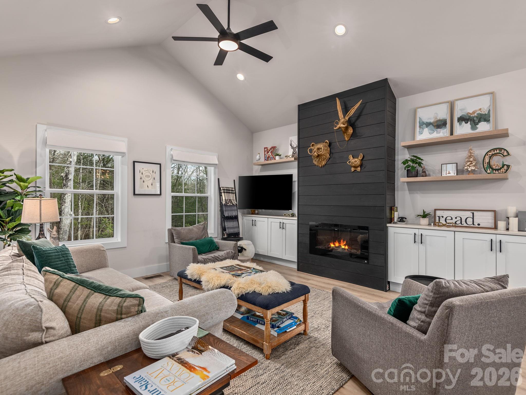 2201 Bulling Creek Road Hendersonville, NC 28739 - Photo 7 of 47 a living room with furniture a flat screen tv and a fireplace