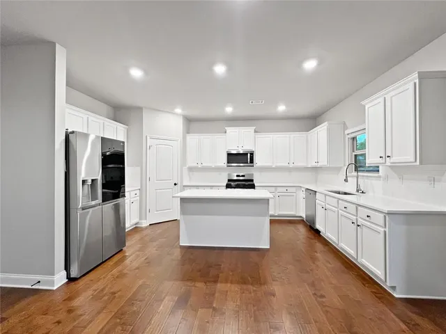 a kitchen with white cabinets and stainless steel appliances