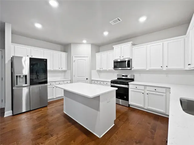 a kitchen with granite countertop white cabinets and white appliances
