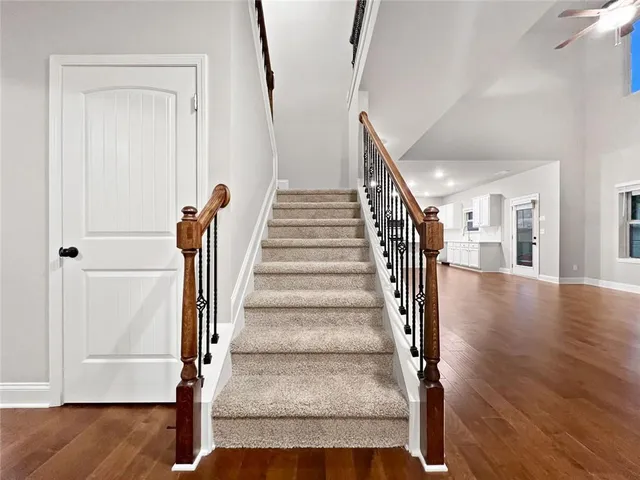 a view of a hallway with wooden floor and stairs