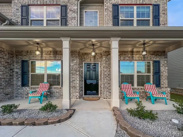 a front view of a building with a garden and chair