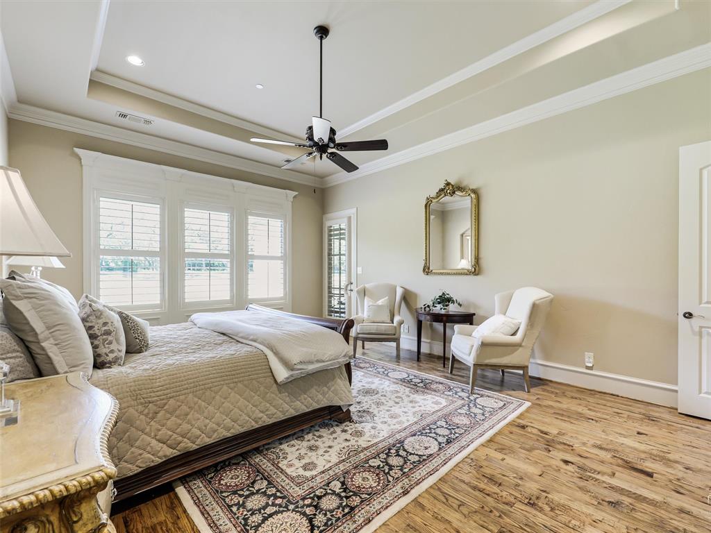 907 Foxglove Trail Fairview, TX 75069 - Photo 19 of 37 a spacious bedroom with a bed a window and couch