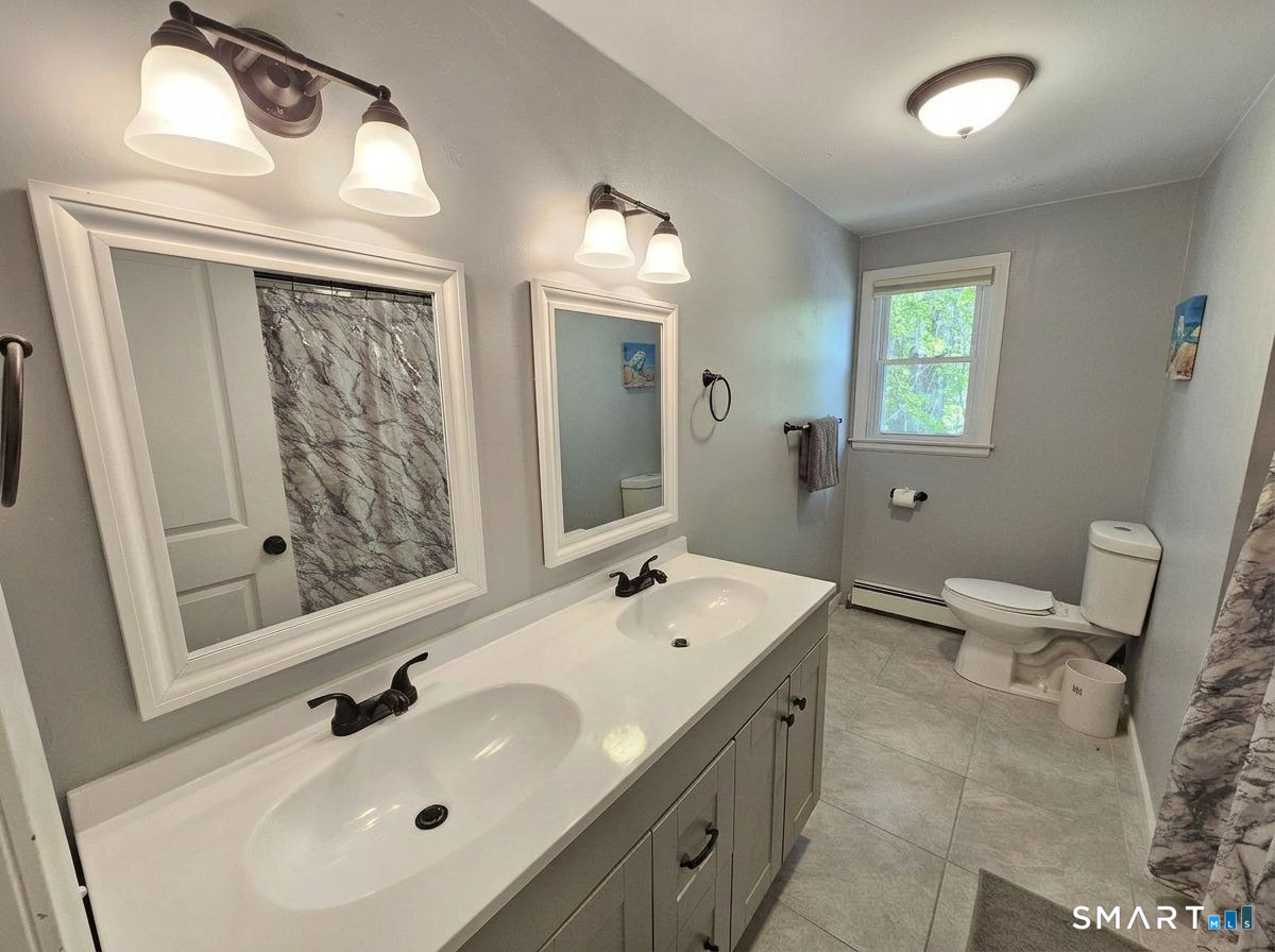 63 Pond Road Windsor, CT 06095 - Photo 14 of 17 a bathroom with a double vanity sink and mirror with toilet