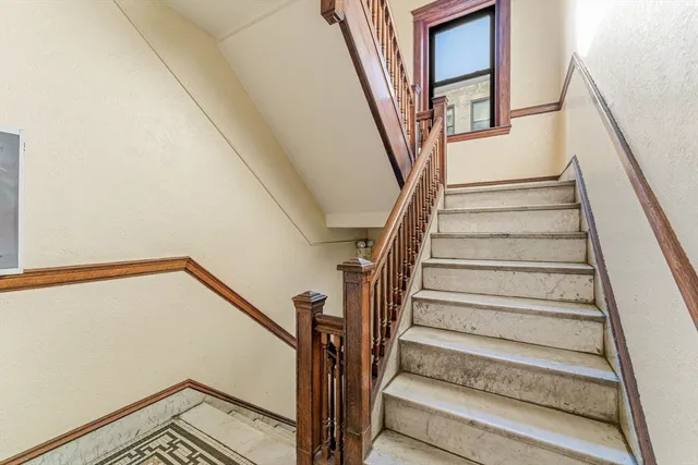 a view of staircase with wooden floor and white walls