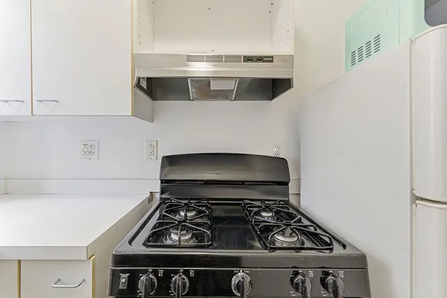 a stove top oven sitting inside of a kitchen
