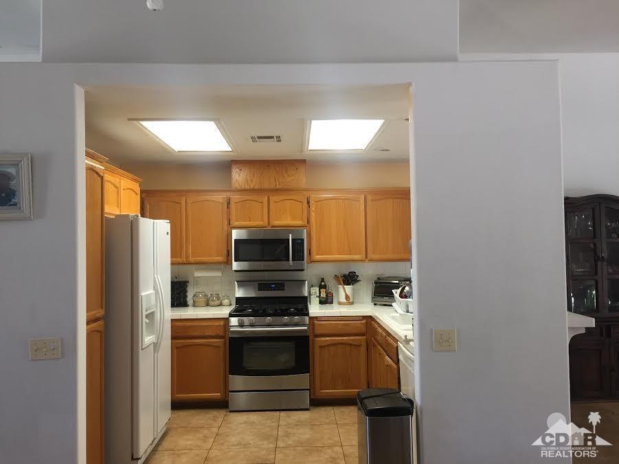 68625 Durango Road Cathedral City, CA 92234 - Photo 9 of 32 a kitchen with a refrigerator and a stove