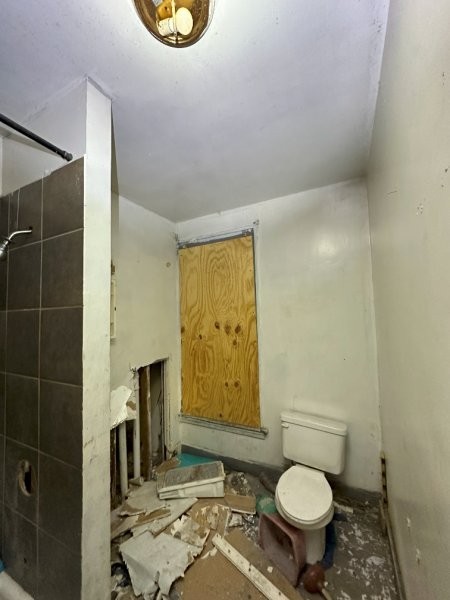 7119 South Emerald Avenue Chicago, IL 60621 - Photo 23 of 50 a bathroom with a toilet sink a mirror and shower
