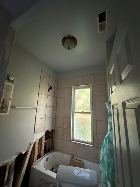 7119 South Emerald Avenue Chicago, IL 60621 - Photo 39 of 50 a bathroom with a tub and window