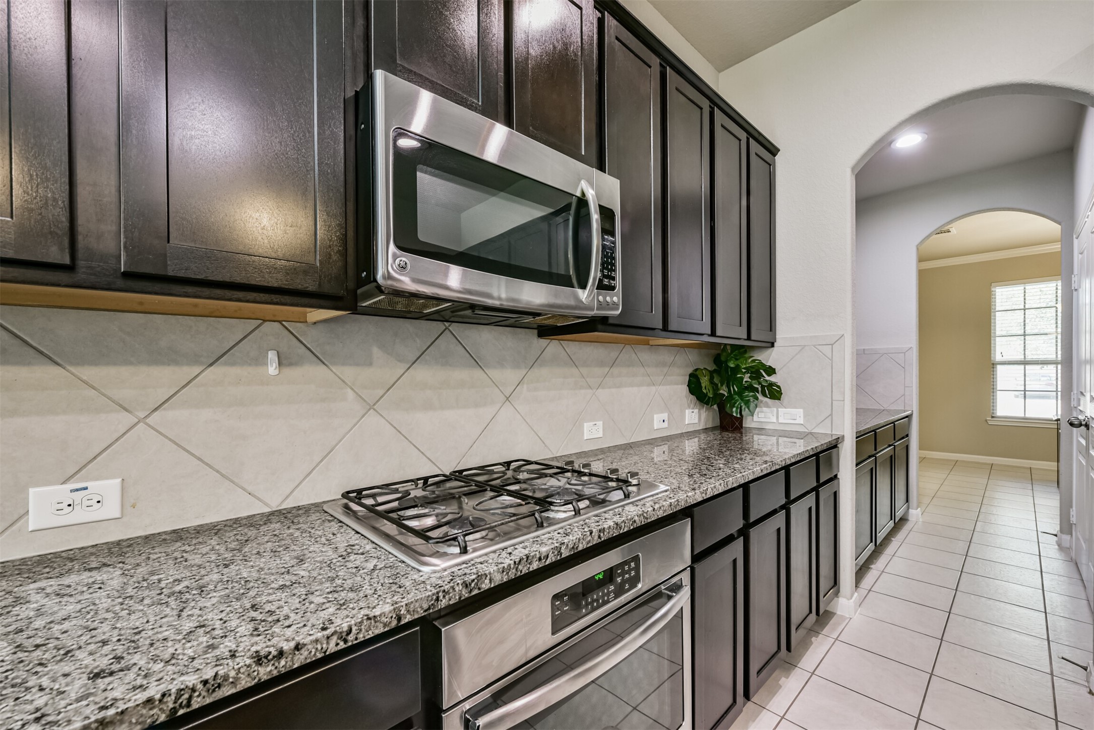 4827 Oak Rambling Drive Katy, TX 77494 - Photo 17 of 45 a kitchen with stainless steel appliances kitchen island granite countertop a stove a microwave and cabinets