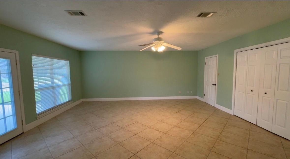 4665 Glen Oaks Circle Beaumont, TX 77708 - Photo 6 of 20 en empty room with windows and fan