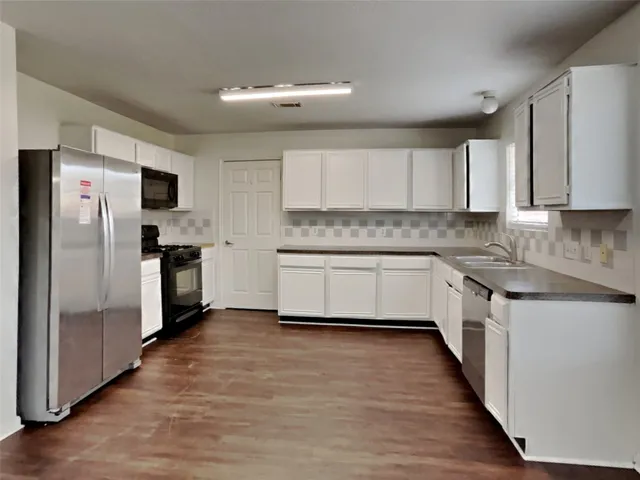 a kitchen with stainless steel appliances a refrigerator sink and cabinets