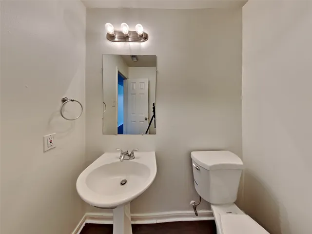 a bathroom with a toilet sink and mirror