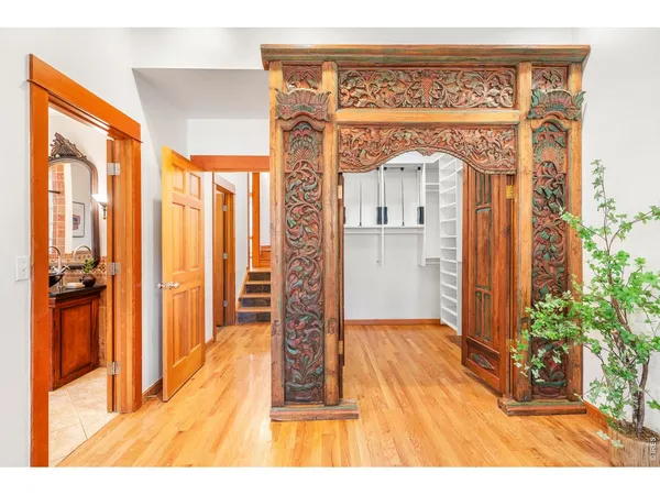 a view of a hallway with wooden floor and a living room