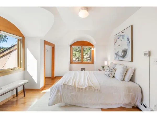 a bedroom with a bed and a large window