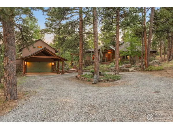 a view of a house with a yard and large tree