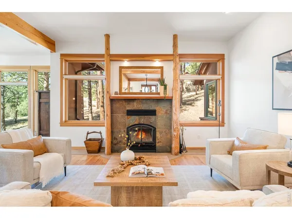 a living room with furniture a fireplace and floor to ceiling windows