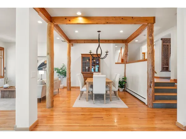 a dining room with wooden floor table and chairs