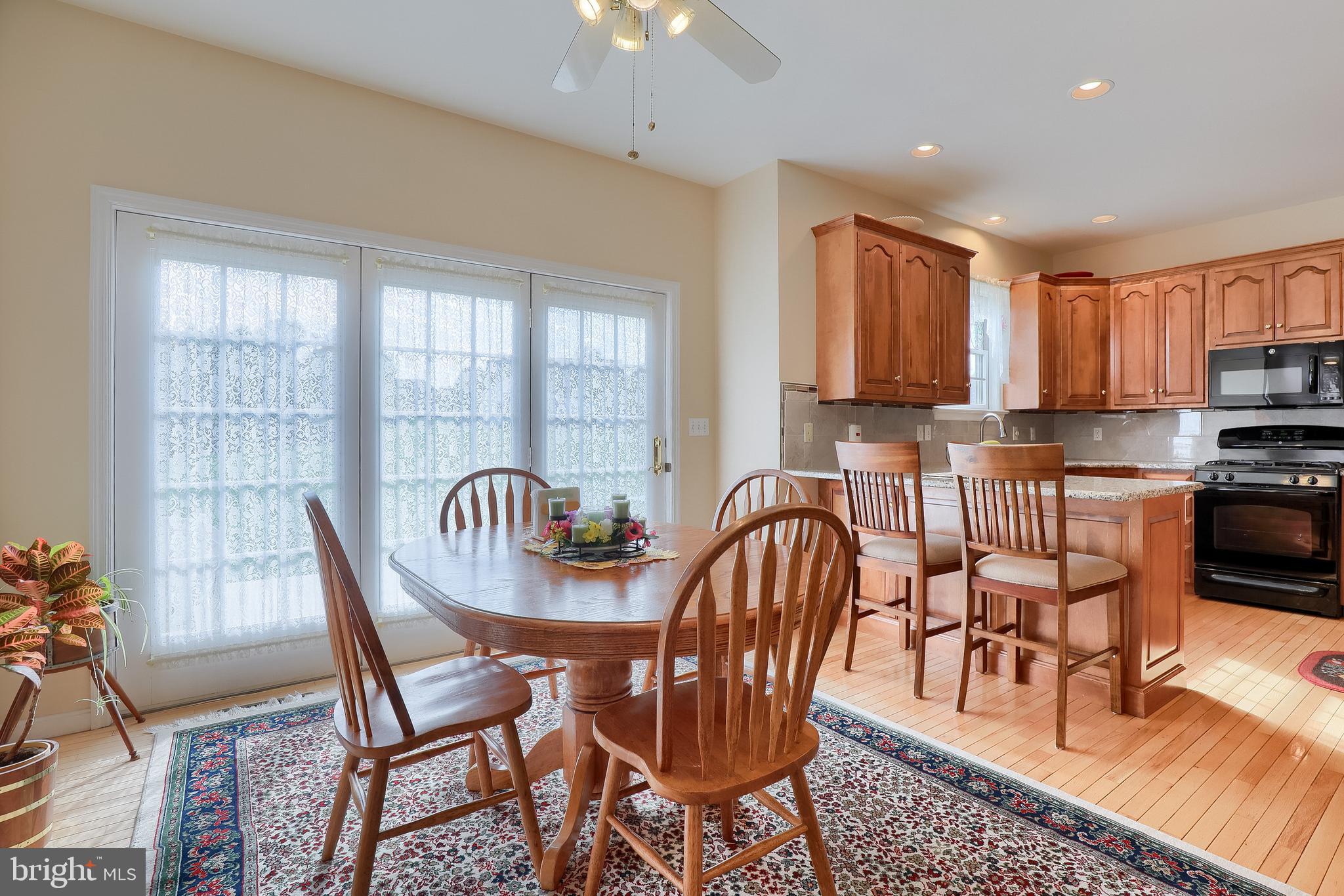 430 Wagonwheel Road Lititz, PA 17543 - Photo 17 of 51 a kitchen with stainless steel appliances granite countertop a stove a sink a dining table and chairs with wooden floor
