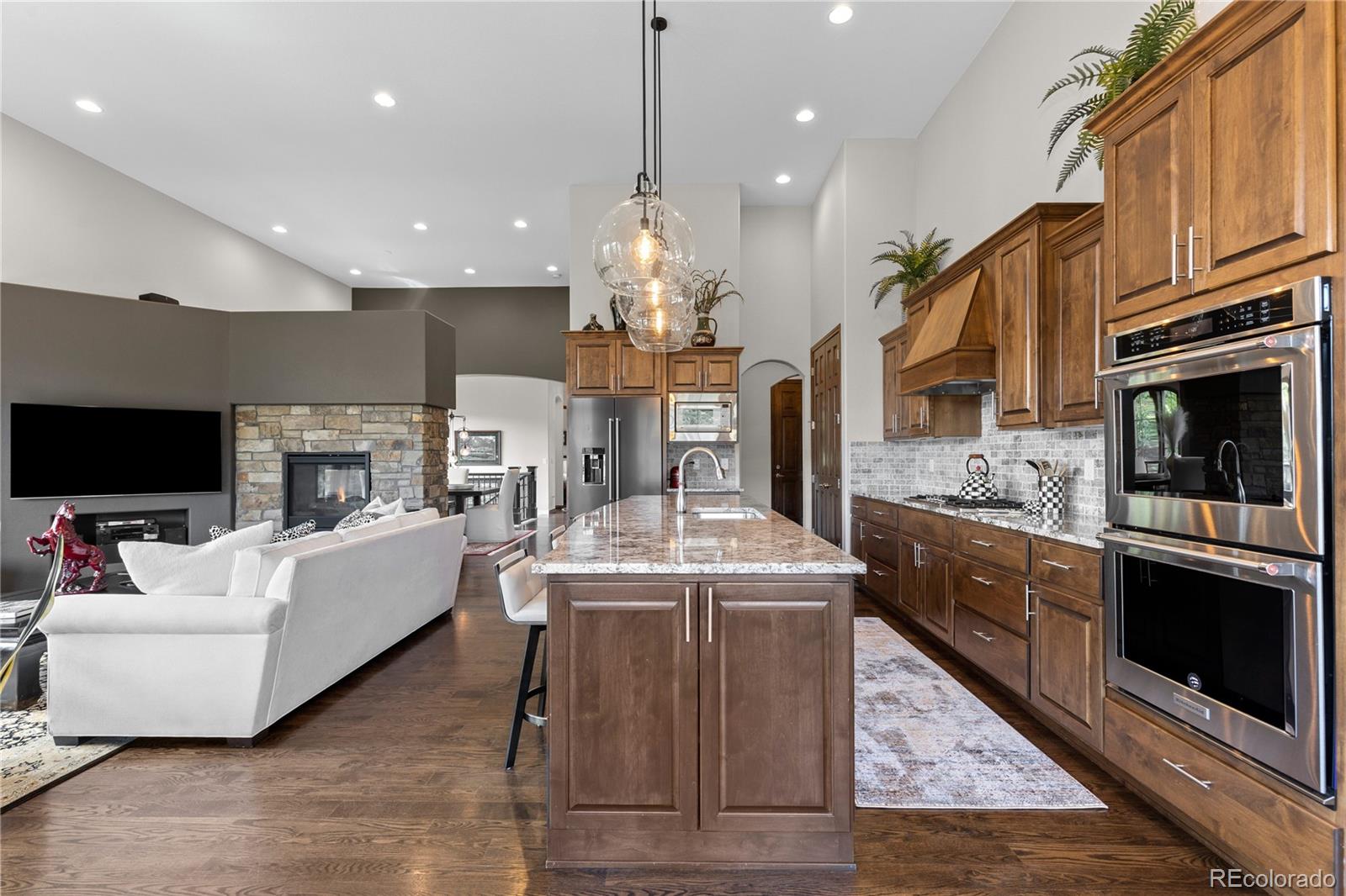 8000 Raphael Lane Littleton, CO 80125 - Photo 15 of 47 a living room with furniture a fireplace and a flat screen tv