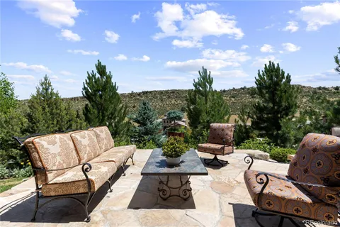 a view of a patio with couches and table and chairs with wooden fence