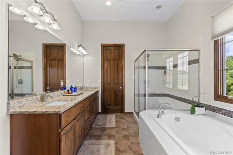 a spacious bathroom with a tub sink and mirror