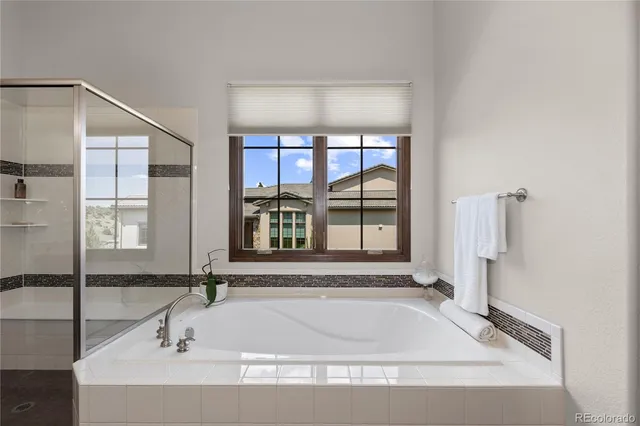 a bathroom with a tub a sink and a window