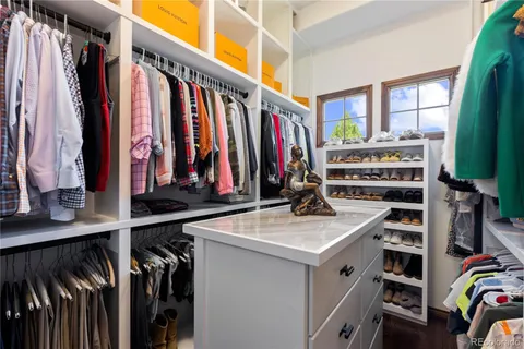 a view of walk in closet with clothes and shoes