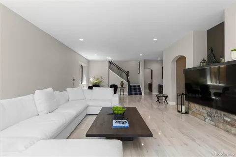 a living room with furniture a flat screen tv and a table