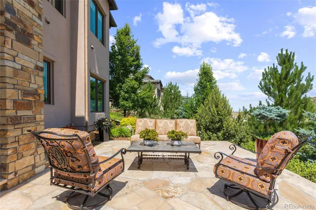 a view of patio with couches table and chairs and potted plants