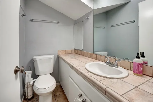 a bathroom with a granite countertop sink toilet and a mirror