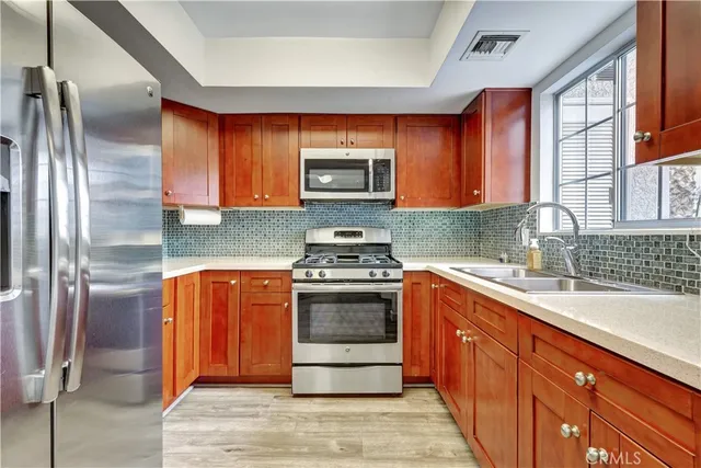 a kitchen with stainless steel appliances granite countertop a stove a sink and a refrigerator