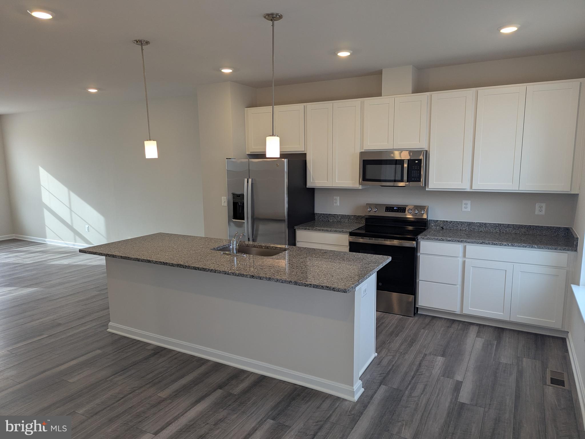 513 Seeback Drive Charles Town, WV 25414 - Photo 15 of 33 a kitchen with kitchen island granite countertop a sink a counter top space appliances and cabinets