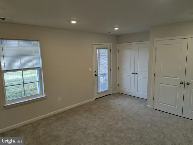 an empty room with windows and closet