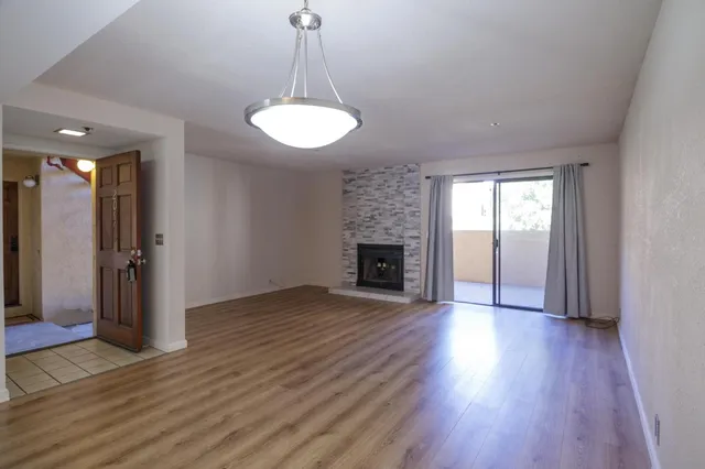 a view of a room with wooden floors and fireplace