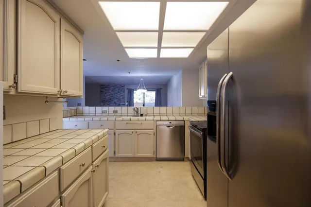 a kitchen with stainless steel appliances granite countertop a sink a stove and a refrigerator