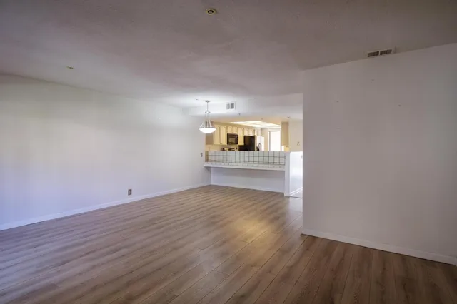 wooden floor in an empty room with a kitchen