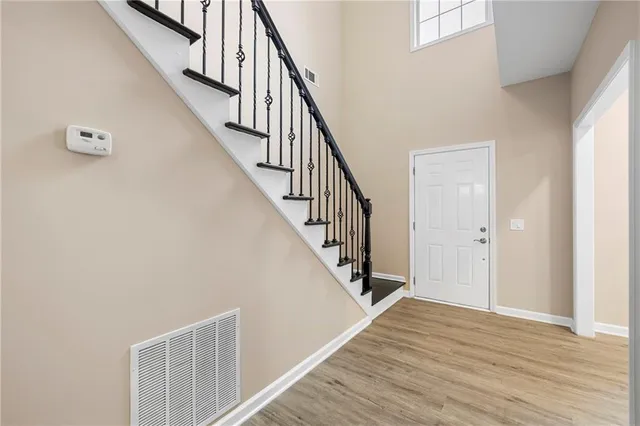 a view of staircase with wooden floor and white walls