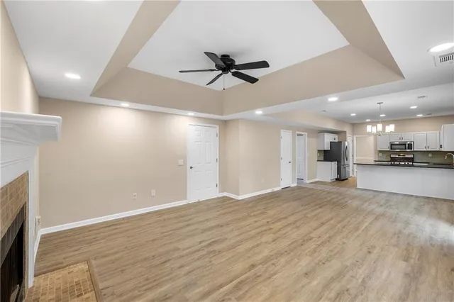 an empty room with a kitchen and a ceiling fan