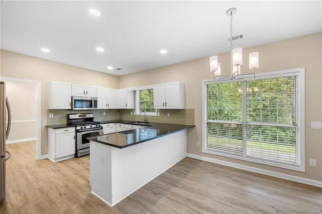 a kitchen with stainless steel appliances granite countertop a sink and a stove