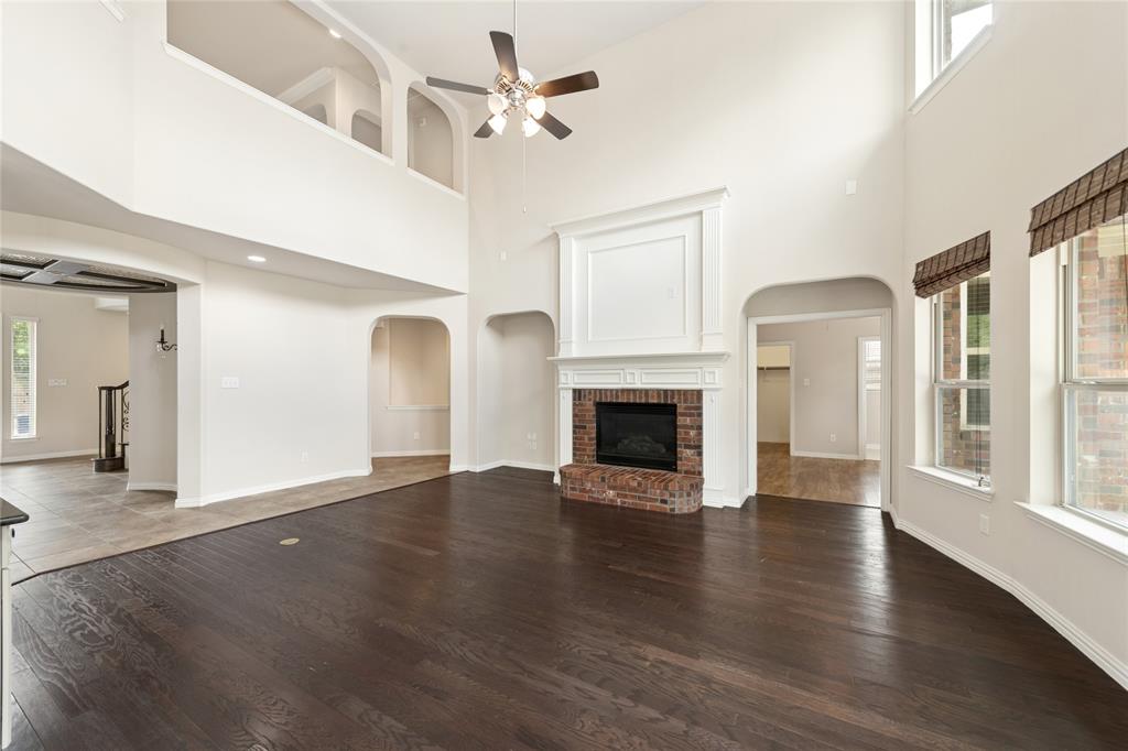 12571 Valley Spring Drive Frisco, TX 75035 - Photo 12 of 39 an empty room with wooden floor fireplace and windows