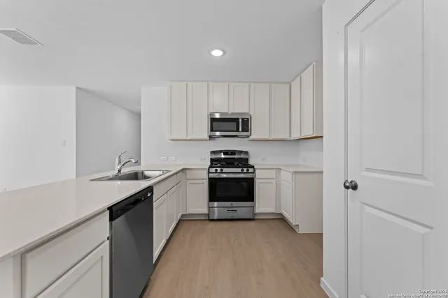 a view of a kitchen with a sink and a refrigerator