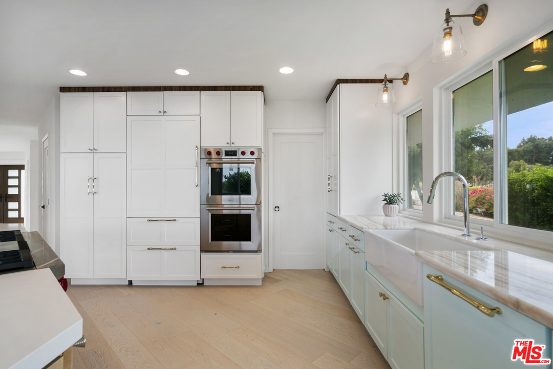 6272 Cavalleri Road Malibu, CA 90265 - Photo 11 of 47 a large white kitchen with a sink and dishwasher with white cabinets