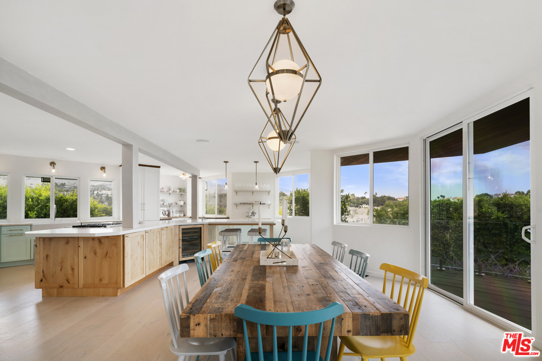 6272 Cavalleri Road Malibu, CA 90265 - Photo 15 of 47 a view of a dining room and livingroom with furniture wooden floor a chandelier