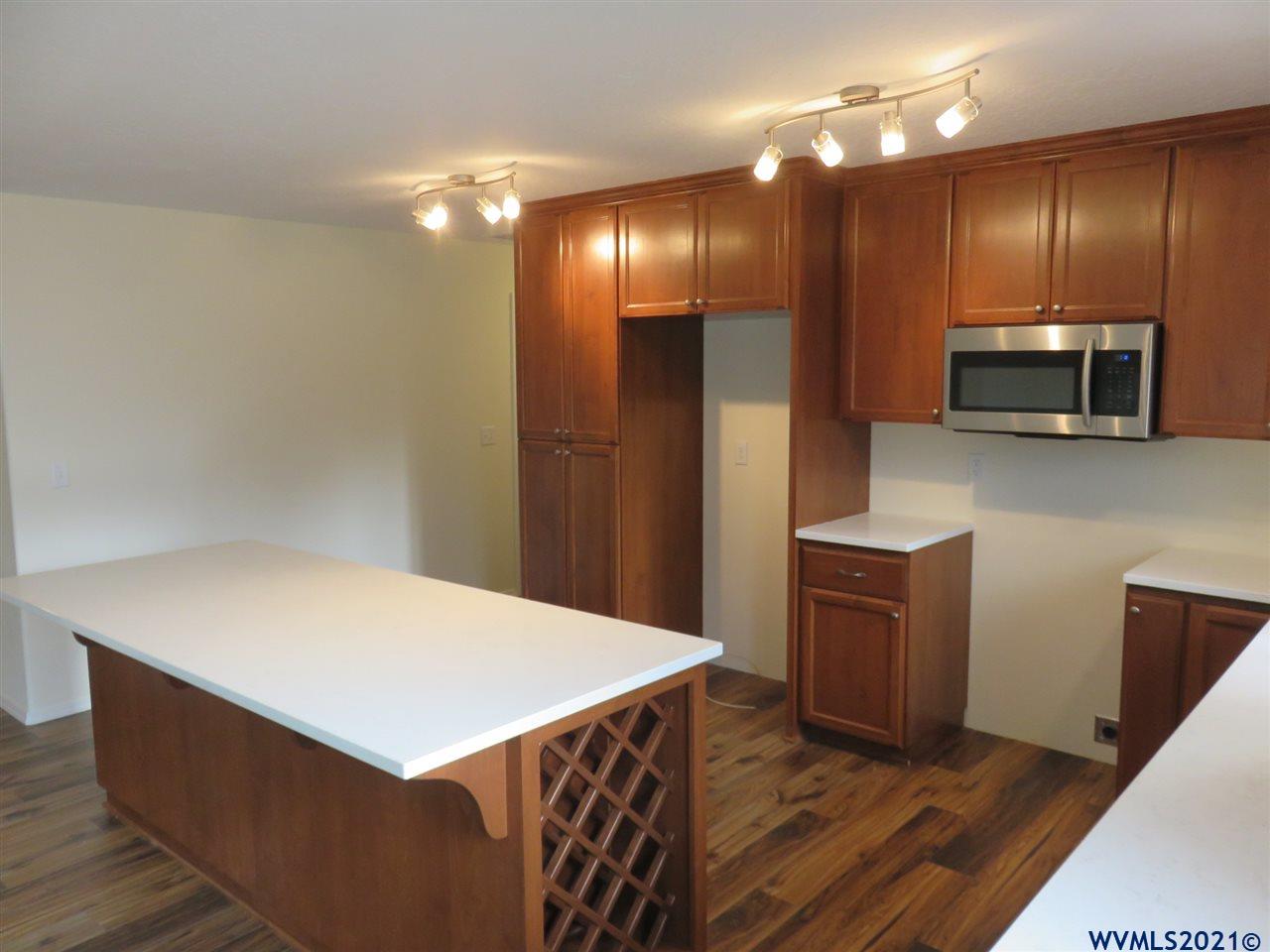 18990 Falls City Road Dallas, OR 97338 - Photo 8 of 42 a kitchen with kitchen island a refrigerator and a sink